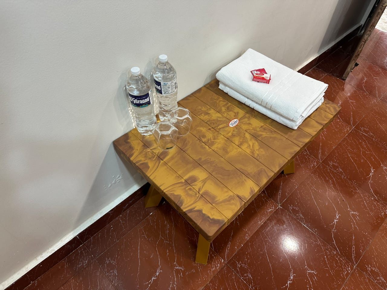 Drinking water, glasses, towels and soap on a side table