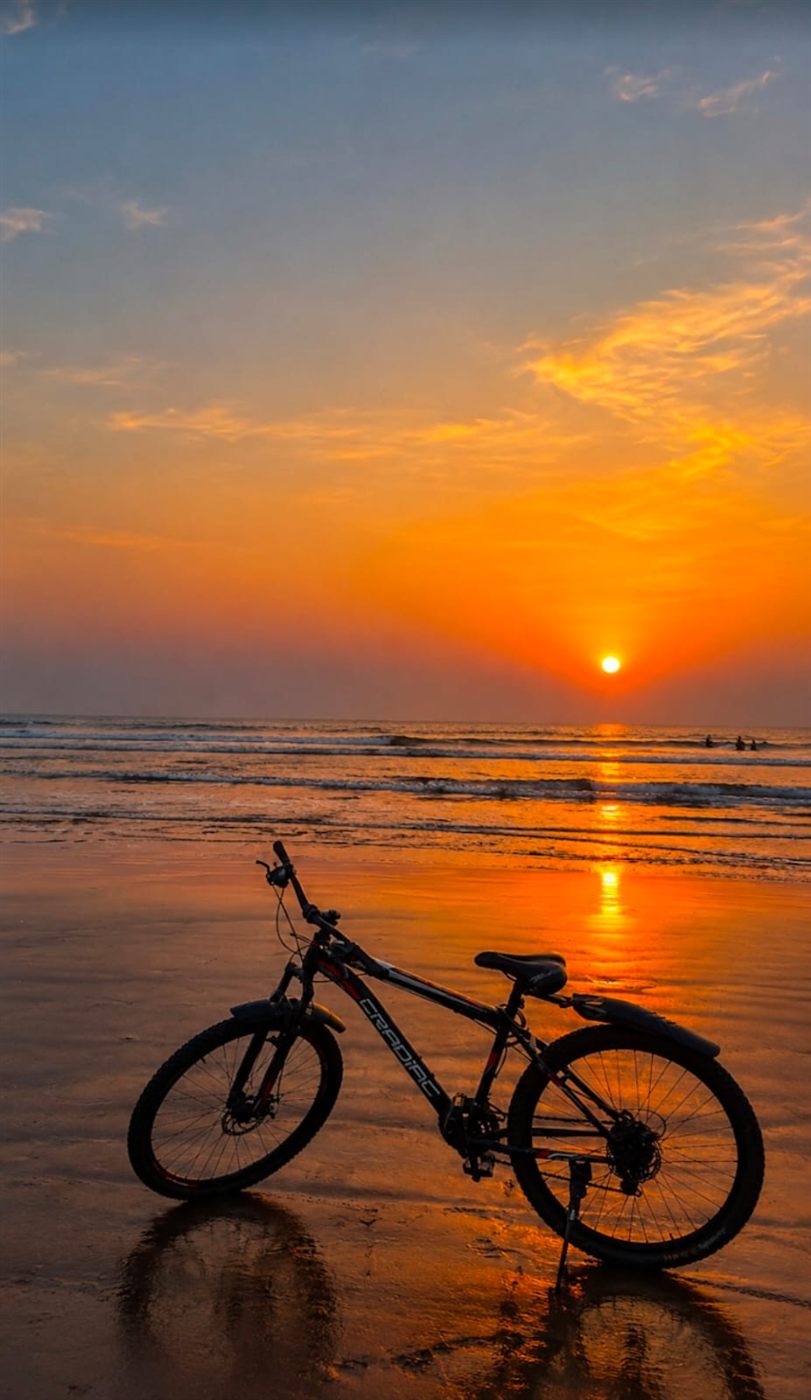 Bicycle on the wet sand at sunset, Harihareshwar beach
